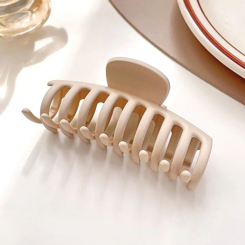 Elegant beige hair claw with solid teeth, perfect for stylish updos and securing hair in place.