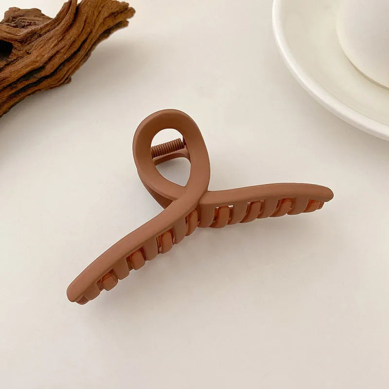 Elegant brown hair claw clip with solid teeth for secure styling, perfect for messy buns and classic updos.