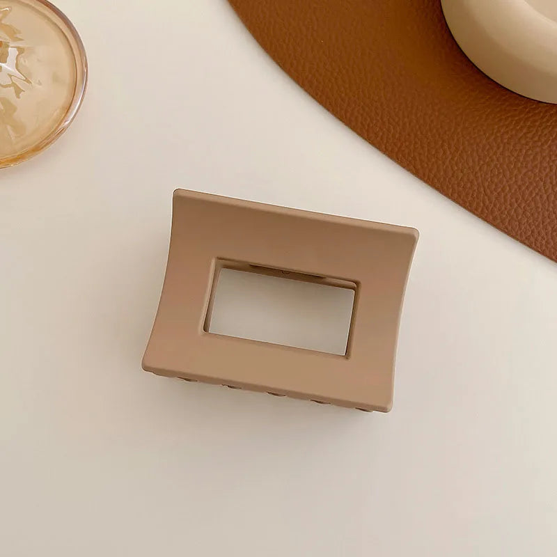 Elegant brown and beige floral geometric hair claw clip on a neutral surface, perfect for stylish hairstyles.