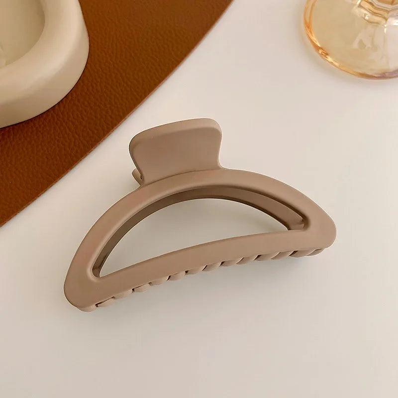 Women’s elegant brown and beige floral geometric hair claw clip on a textured surface.