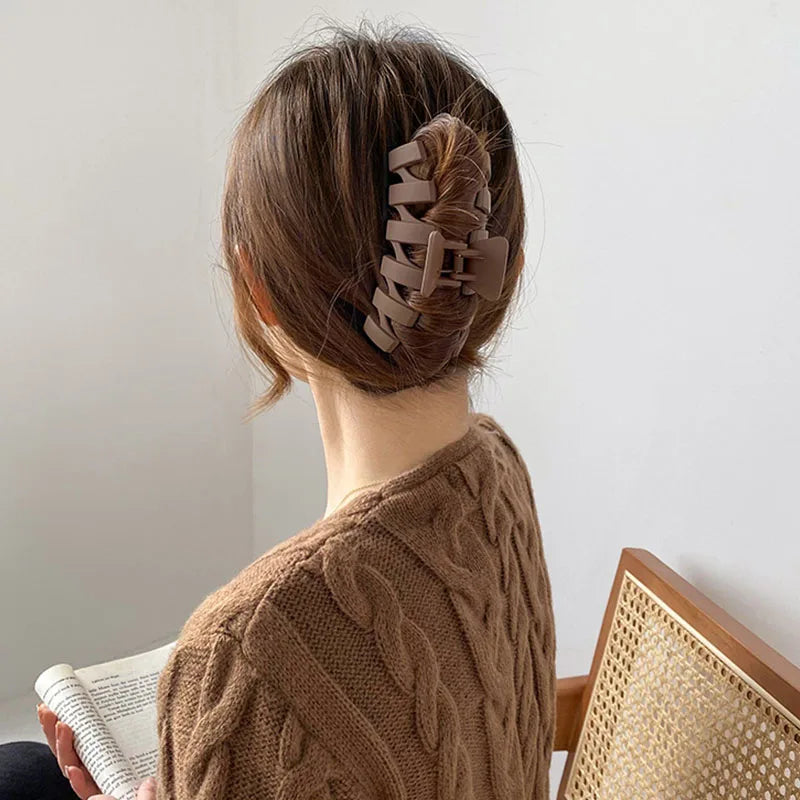 Woman wearing a brown and beige floral geometric hair claw clip in a stylish hairstyle.