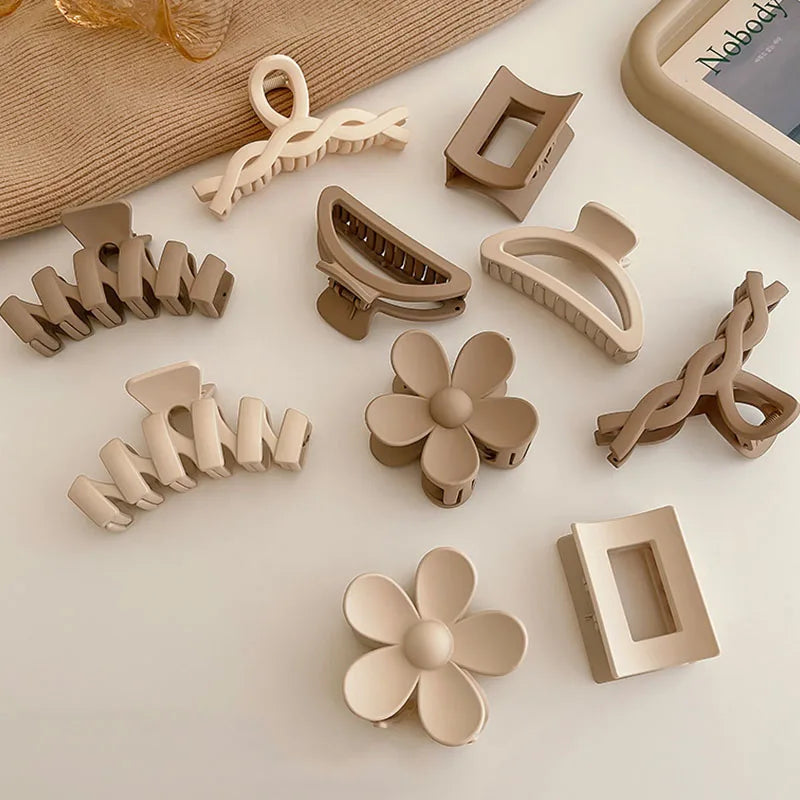 Collection of elegant brown and beige floral geometric hair claws arranged neatly on a surface.