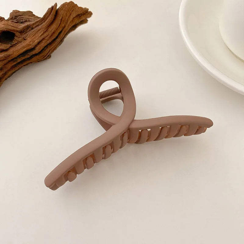 Elegant brown and beige floral geometric hair claw clip on a white surface, perfect for versatile hairstyles.