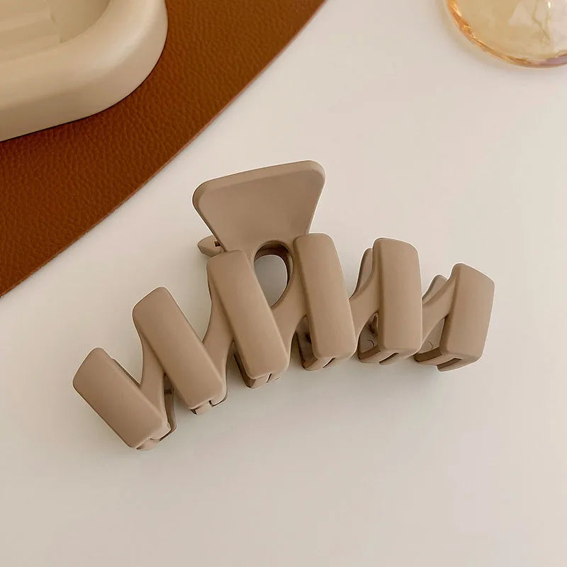 Elegant solid-toothed beige hair claw clip for stylish hair updos and everyday hairstyles.