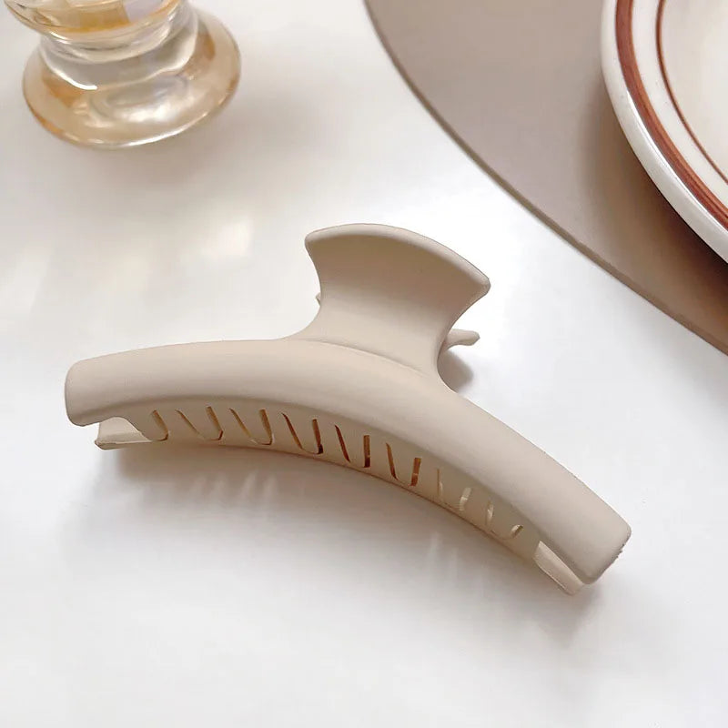 Neutral beige geometric hair claw clip, ideal for securing stylish hairstyles like buns and half-updos.
