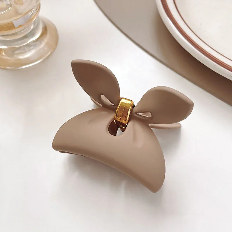 Elegant beige floral geometric hair claw clip with gold accents for stylish hairdos.