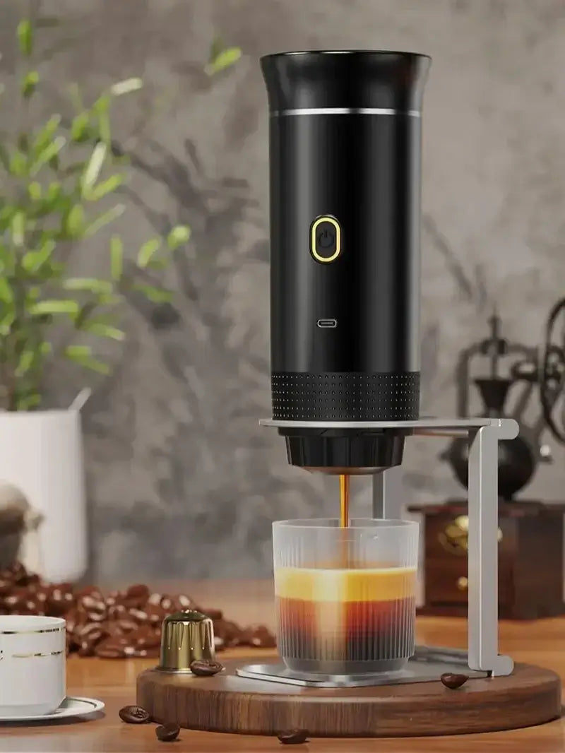 Portable espresso coffee machine brewing rich coffee in clear cup, perfect for travel and camping.