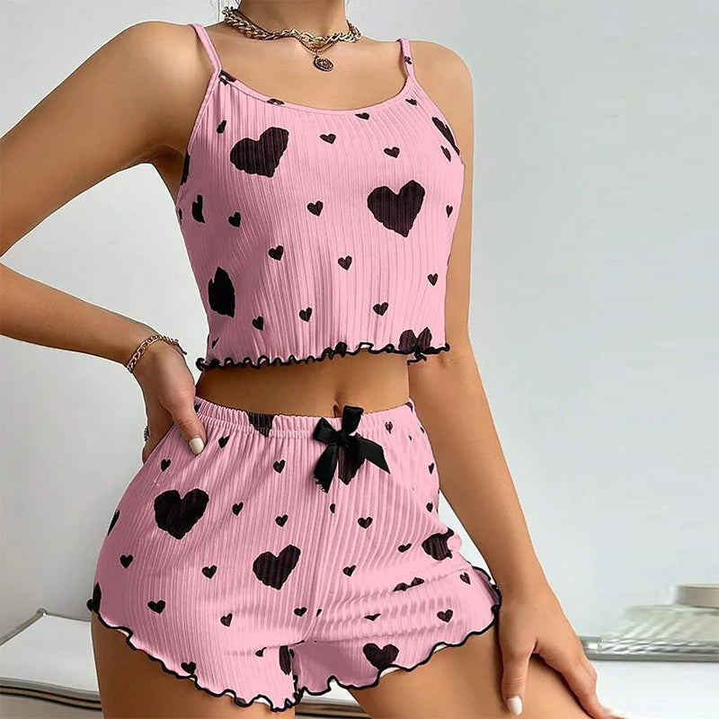 Women's pink heart-patterned summer pajamas set with soft tank top and shorts for cozy lounging.