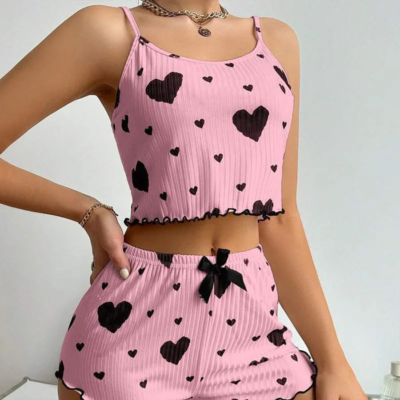 Women's summer pajamas set featuring a pink tank top and shorts with black heart prints, perfect for warm nights.